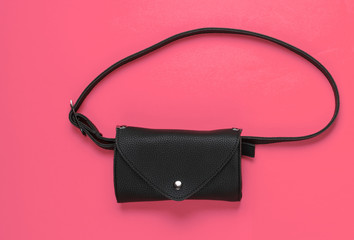 Stylish belt bag on pink background. Top view