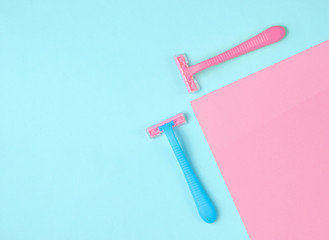 Minimalistic beauty concept. Epilation. Plastic colored razors on pastel background. Top view
