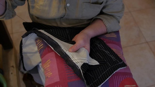 Fashion designer hands pad stitching a suit lapel Pad stitches secure two or more layers of fabric together and give the layers more firmness
