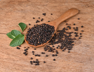 Black pepper and mint leafs on the wooden table