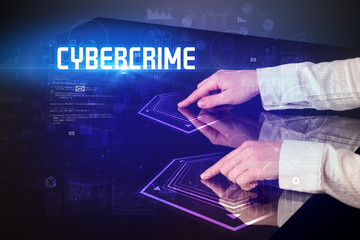 Hand touching digital table with CYBERCRIME inscription, new age security concept