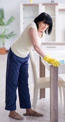 Old mature woman tired after house chores