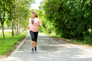 Healthy woman jogging run and workout on road outdoor. Asian runner people exercise gym with fitness session, nature park background. Healthy and Lifestyle Concept.