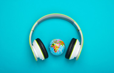 World song. Global music chart. The music of earth. Stereo headphones and globe on blue background....