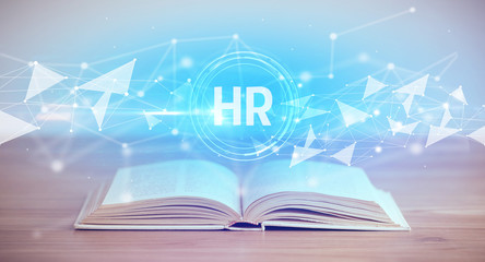 Open book with HR abbreviation, modern technology concept