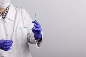 a medical worker with an ampoule of medicine and a syringe is going to be vaccinated