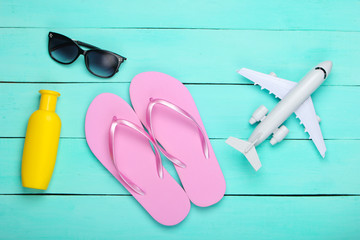 Flat lay composition of beach vacation, resort and travel. Flip flops, airplane, sunglasses, bottle...
