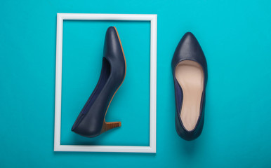 Women's classic high-heeled shoes on blue background with a white frame. Fashion shot. Creative flat lay. Top view. Minimalism