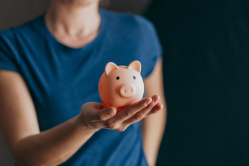 female hands protect pink piggy bank, copy space. Concept of saving money or savings