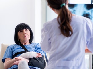 Doctor examining old mature woman after incident