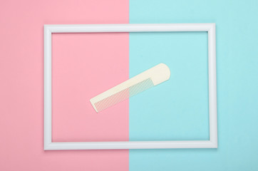 Comb in a white frame on a blue-pink pastel background. Top view
