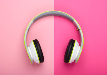 Stylish wireless stereo headphones on pink pastel background. Music lover. Gadgets. Top view.