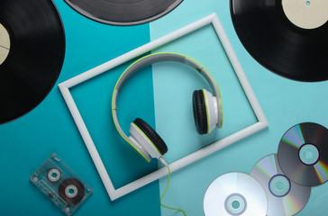 Flat lay composition from retro media, 80s. Stylish stereo headphones in white frame, vinyl...