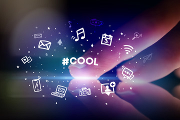 Finger touching tablet with drawn social media icons and #COOL inscription, social networking concept