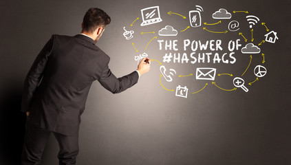 businessman drawing social media icons with THE POWER OF #HASHTAGS inscription, new media concept