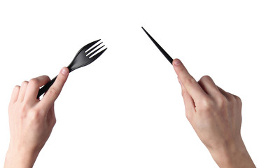 Female hands hold black plastic knife with a fork isolated on white background