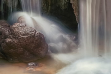 view of silky waterfall around with arch rocks background, Kroeng Krawia Waterfall, Sangkhla Buri, Kanchanaburi, west of Thailand.