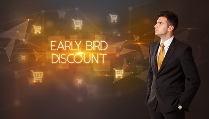 Businessman with shopping cart icons and EARLY BIRD DISCOUNT inscription, online shopping concept