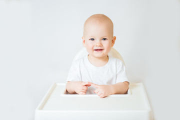 Portrait of a cute baby boy smiling sitting at the table looking at the camera