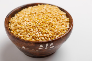 yellow moong mung dal lentil pulse bean in wooden bowl on white background