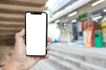 Asian man holding phone mock up center frame at supermarket open application check order isolated display for insert screen