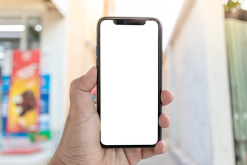 Asian man holding phone mock up center frame at supermarket open application check order isolated display for insert screen