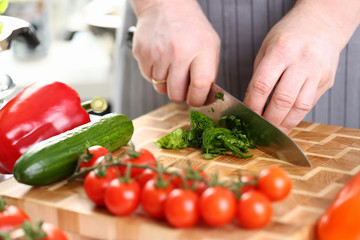 Male Hands Cutting Green Aromatic Sorrel Leaf. Man Cooking Vegetable on Wooden Board at Kitchen. Slicing Ingredient by Sharp Knife. Dieting Product. Organic Food Assortment Horizontal Photography