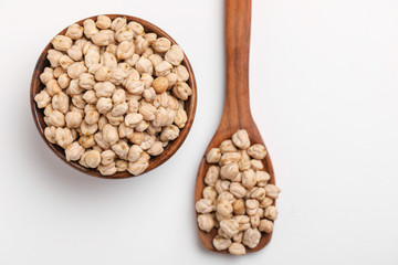 Uncooked dried chickpeas in wooden bowl and spoon