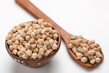 Uncooked dried chickpeas in wooden bowl and spoon
