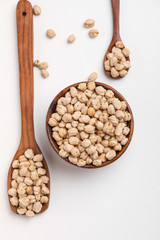 Uncooked dried chickpeas in wooden bowl and spoon
