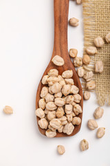 Uncooked dried chickpeas in wooden bowl