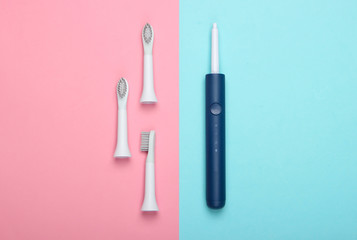 Teeth care. Modern electric toothbrush with nozzles on pink blue background. Top view. Minimalism