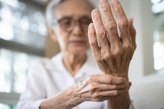 Elderly female patient suffer from numbing pain in hand,numbness fingertip,arthritis inflammation,beriberi or peripheral neuropathies,senior woman massage her hand with wrist pain,rheumatoid arthritis