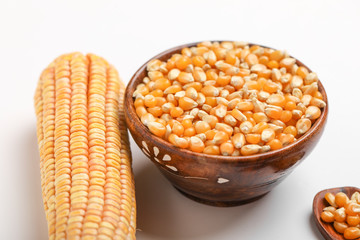 Dried corn seeds in bowl on white background