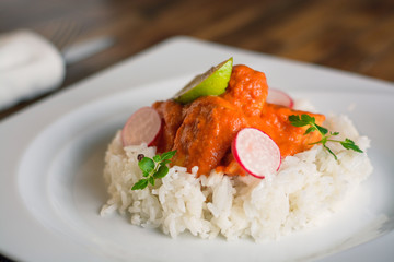 Closeup shot of a delicious salmon fillet in sauce with rice on a withe plate
