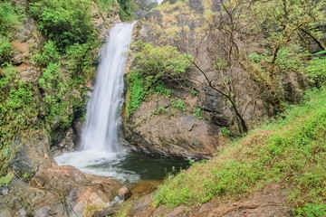 Fototapeta na wymiar view of silky waterfall flowing on cliff rocks around with green forest background, Mae Pan Waterfall, Doi Inthanon National Park, Chiang Mai, northern of Thailand.