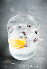 Gin based cocktail with lemon slice and juniper berries. Selective focus. Shallow depth of field.