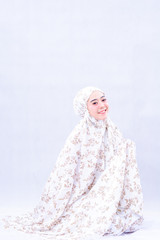 portrait of beautiful muslim woman sit and pray wearing muslim hijab scarf isolated on white background