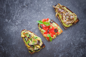 Bruschetta on a dark background, Assorted bruschetta, Top view, Italian toasted crusty ciabatta bread