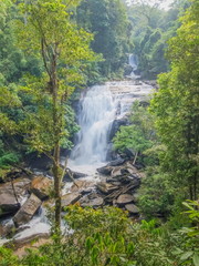 view of silky waterfall flowing around with green forest background, Sirithan Waterfall, Doi Inthanon National Park, Chiang Mai, northern of Thailand.