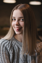 Fototapeta premium Portrait of a young female with funny face expression. Teenager showing her tongue. Funny mood