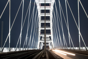 Fototapeta na wymiar Arch bridge from inside. White bridge by night. Suspension bridge.