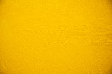 Blurred Yellow stucco wall background. Yellow painted cement wall texture.