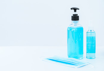 Alcohol gel and  Blue face mask protection against pollution flu and coronavirus on background. Health care concept.on white background.Covid-19 concept with copy space