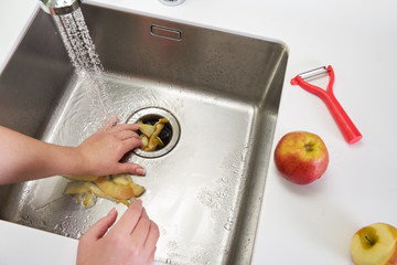 Food waste disposer machine in sink in modern kitchen
