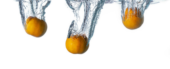 Orange or tangerine falls deeply underwater with big air bubble splash. isolated on white background, Concept fresh fruit