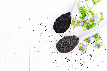 Flour and seeds of kalingi in spoons on light board top