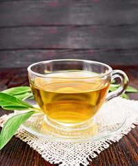 Tea herbal with sage in glass cup on wooden board