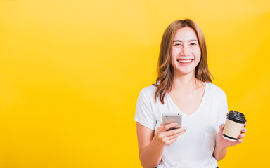 woman standing smile, using mobile phone her holding coffee paper cup