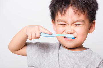 Closeup Asian face, Little children boy hand holds toothbrush he brushing teeth myself